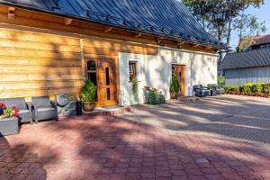 a house with a brick patio with chairs in front of it at Apartament u Majerczyka in Zakopane