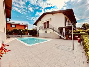 uma villa com piscina em frente a uma casa em Rea Apartment - 500 m dal Lago con Piscina em Sirmione