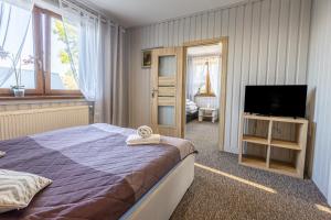 a bedroom with a bed and a flat screen tv at Apartament u Majerczyka in Zakopane