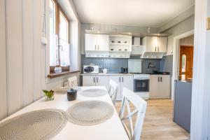 a kitchen with white cabinets and a table and chairs at Apartament u Majerczyka in Zakopane