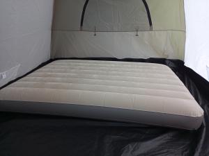 a bed in a small room with a mattress at Hostel Pé na praia - Quartos e Barracas Camping in Caraguatatuba