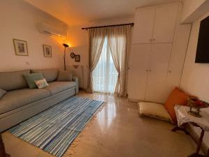 sala de estar con sofá y alfombra en Schönes Familienappartement in Pelekas, Corfu mit Meerblick en Pelekas