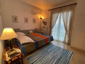 1 dormitorio con 1 cama y 1 mesa con lámpara en Schönes Familienappartement in Pelekas, Corfu mit Meerblick, en Pelekas