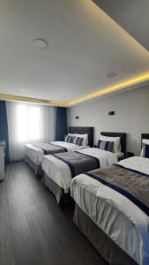 a row of four beds in a hotel room at SAND DOOR HOTEL in Istanbul