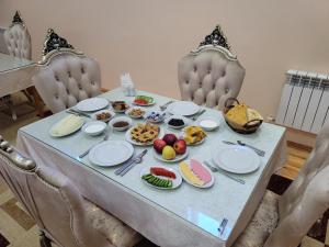 a table with plates of food on it at Khiva Siyovush Hotel in Khiva