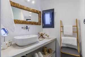 a bathroom with a white sink and a mirror at To Nissi in Skopelos Town +79 photos