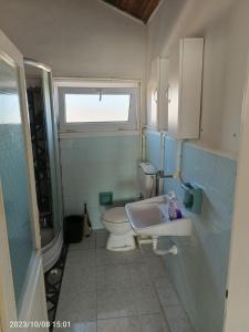 La salle de bains est pourvue de toilettes, d'un lavabo et d'une fenêtre. dans l'établissement DENİZ YILDIZI, à Marmaraereglisi