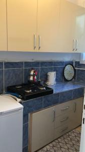 Il comprend une cuisine équipée d'une cuisinière et d'un comptoir bleu. dans l'établissement DENİZ YILDIZI, à Marmaraereglisi