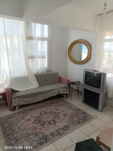 a living room with a couch and a tv at DENİZ YILDIZI in Marmaraereglisi