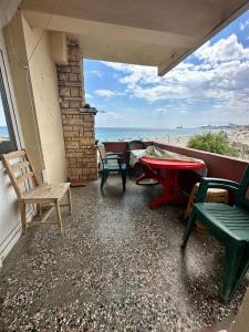 d'une terrasse avec des chaises et une table et une vue sur la plage. dans l'établissement DENİZ YILDIZI, à Marmaraereglisi