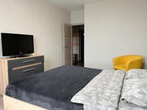 a bedroom with a bed and a tv and a chair at 093 квартира ЖК Щасливий, укриття в комплексі in Kyiv