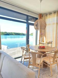 a dining room with a table and a view of the water at Dom z sauną i widokiem na jezioro in Pluski