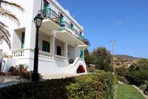 a white house with stairs and a light pole at Blue Dolphin in Batsi