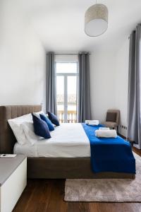 a bedroom with a large bed with blue pillows at San Marco Black Appartamento Luxury con Terrazzo e Parcheggio su richiesta in Florence