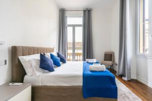 - une chambre avec un grand lit et des oreillers bleus dans l'établissement San Marco Black Appartamento Luxury con Terrazzo e Parcheggio su richiesta, à Florence