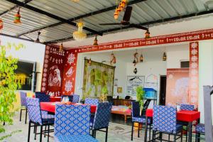 a dining room with red walls and blue chairs at Hill Paradise Home Stay in Udaipur