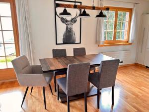 una sala da pranzo con tavolo e sedie in legno di Höhwald - Maranerhang a Arosa