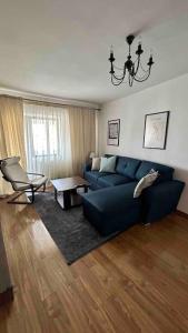 a living room with a blue couch and a chair at Georgiana’s central apartment in Buzău