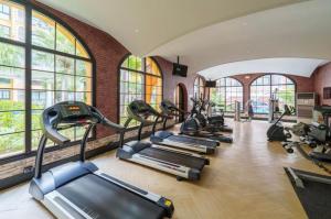 a row of treadmills in a gym with windows at Venetian Resort Pattaya in Jomtien Beach