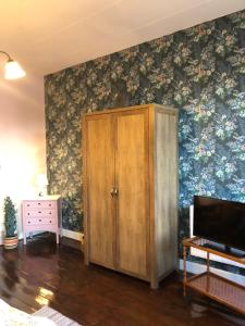 una habitación con un armario y una pared con flores en Cafebrumman, en Neksø