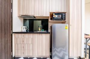 a kitchen with a refrigerator and a microwave at Venetian Resort Pattaya in Jomtien Beach