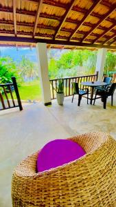 a purple rug on a patio with a table and chairs at Emma's Sea View in Hiriketiya