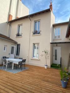a patio with a table and chairs and a building at Maison Cosy à Vichy in Vichy