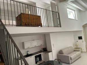 a living room with a staircase with a couch and a chair at A 2 passi dal centro in Palazzolo Acreide