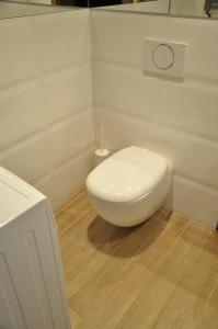 een witte badkamer met een toilet in de hoek bij Apartament Starowiejska in Gdynia