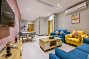 Amar suites في الرياض: غرفة معيشة مع أرائك زرقاء وطاولة