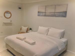 un letto bianco con due asciugamani sopra di IKKYU2 Angthong อิคคิว2 a Ang Thong