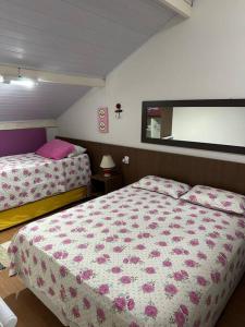 1 Schlafzimmer mit 2 Betten mit rosa Bettwäsche und einem Fenster in der Unterkunft MARA Maranduba! Apê c/ Piscina. in Ubatuba
