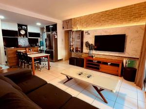 a living room with a couch and a tv and a table at Beach Living - Porto das Dunas - Ap Terreo 200m Beach Park PÉ NA AREIA in Aquiraz