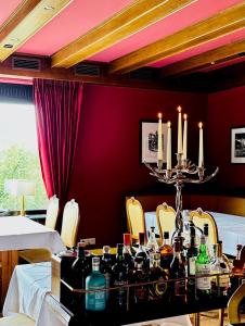 a dining room with a table with bottles and candles at Landhotel Bellevue in Wolfshausen