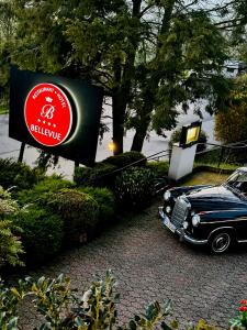 ein Auto, das neben einem Schild für ein Biliaryvy parkt in der Unterkunft Landhotel Bellevue in Wolfshausen