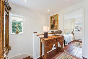 Zimmer mit einem Tisch mit einer Lampe und einem Bett in der Unterkunft Pass the Keys Hidden Cottage in Esher, West End in Esher