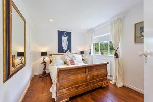 a bedroom with a bed and a large window at Hidden Cottage with Parking in Esher Surrey - Pass the Keys in Esher