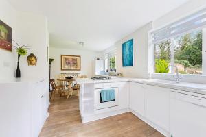 a kitchen with white appliances and a dining room at Pass the Keys Hidden Cottage in Esher, West End in Esher