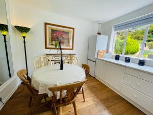 a kitchen with a table and chairs and a window at Hidden Cottage with Parking in Esher Surrey - Pass the Keys in Esher