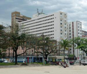 a large white building in the middle of a city at Vista ao mar no Gonzaga in Santos