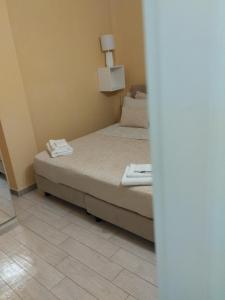 a small bedroom with a bed and a tiled floor at Da lea affitta camere in Bologna