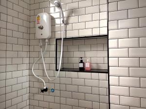 e bagno piastrellato bianco con doccia. di IKKYU2 Angthong อิคคิว2 a Ang Thong