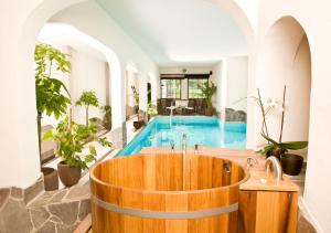 eine Badewanne in der Mitte eines Zimmers mit Pool in der Unterkunft Hotel Lellmann in Löf
