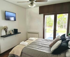 a bedroom with a large bed with a tv on the wall at Casa en la mejor ubicación! in Mendoza +24 photos