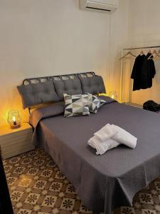 een slaapkamer met een groot bed met twee kussens bij Amira Apartments Trapani in Trapani