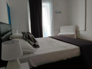 een slaapkamer met een wit bed en een raam bij Amira Apartments Trapani in Trapani