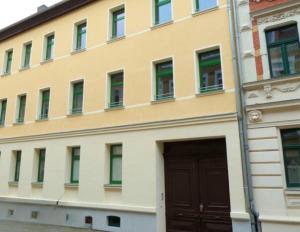 un edificio con una puerta delante en moderne Einraumwohnung mit eigenem Bad, Parkplatz, Balkonnutzung, zentrumsnah - In 10 Minuten mit dem Rad oder dem ÖPNV zur Arena und in Leipzigs Innenstadt, en Leipzig