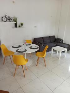 uma sala de estar com uma mesa e cadeiras amarelas em Chez Fèmi, route des pêches em Cotonou
