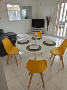 a living room with a table and yellow chairs at Chez Fèmi, route des pêches in Cotonou