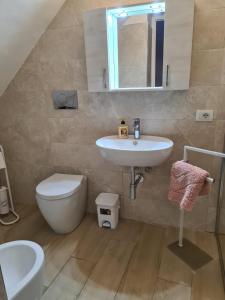 a bathroom with a sink and a toilet and a mirror at Casa del papà in Noto